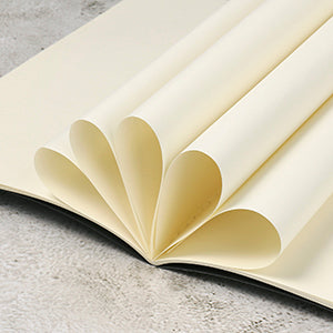 Open book with cream-colored pages on a gray surface