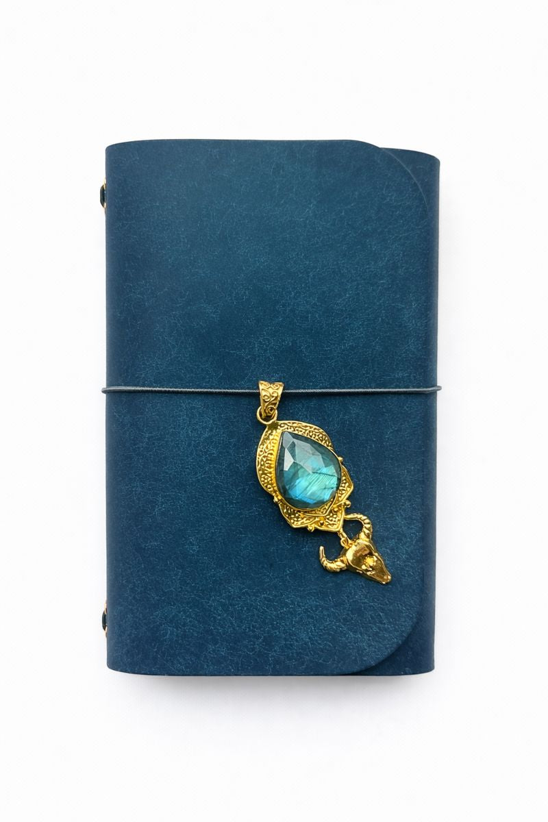Shadowhorn Mini Ritual A6 Journal - navy veg tan matte leather journal with smoky grey cording and a rose Cut Labradorite with Bull Skull Brass front charm. 