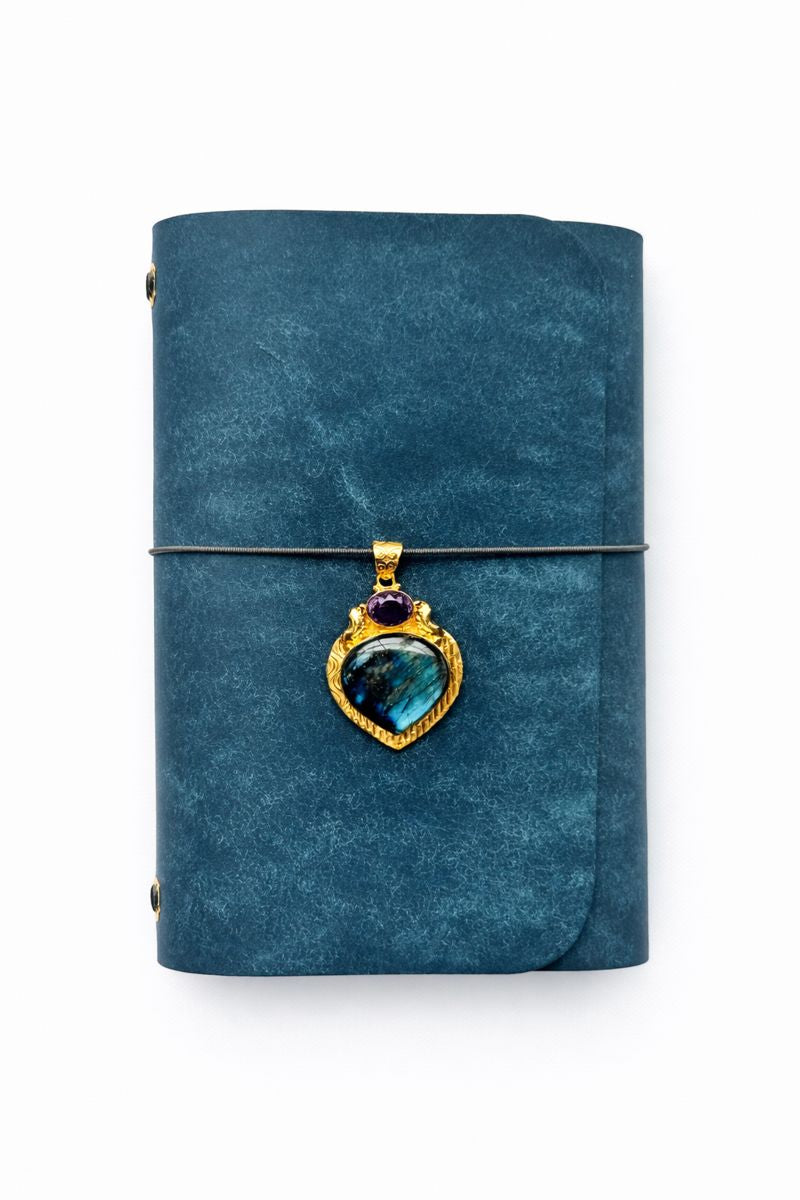 Celestial Bloom Ritual A5 Journal - navy veg tan matte leather journal with smoky grey cording and a Heart-shaped blue labradorite + faceted amethyst front charm.