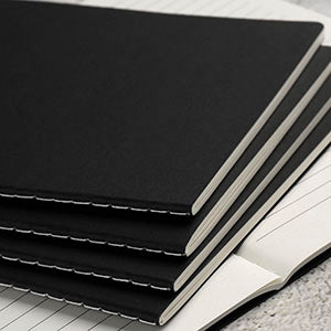 Stack of black notebooks on a textured surface
